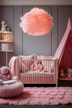 a baby's room with pink bedding and accessories on the floor, in front of a gray wall