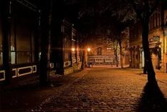 an empty city street at night with the lights on