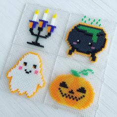 cross stitch halloween magnets with candles and pumpkins in them on a white surface