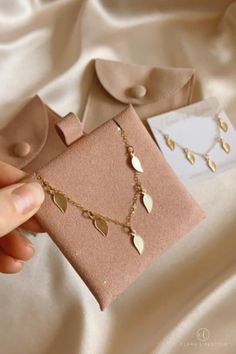 Our Golden Leaf Necklace is beautifully golden and subtle. Featuring five subtle golden leaves which catch sunlight in the most beautiful way, this piece takes us back to nature and symbolizes new beginnings and growth. Layer this chain easily with existing pieces for an everyday look you’ll love! Minimalist Packaging, Lifestyle Jewelry, Golden Honey, Jewelry Pouches, Golden Leaf, Herringbone Chain, Boho Luxe, Golden Leaves, Back To Nature