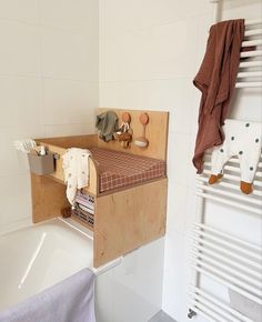 a bathroom with a sink, towel rack and radiator in the bathtub