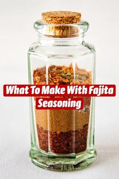 a glass jar filled with spices on top of a white table