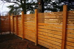 a wooden fence in front of a tree