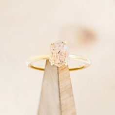 a diamond ring sitting on top of a wooden stand