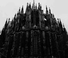 a very tall building with many spires on it's sides in black and white