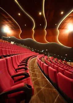 an empty auditorium with red seats and lights