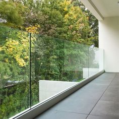 an empty room with glass walls and trees in the background