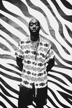 a man is standing in front of a zebra print wall with his hands on his hips