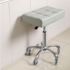 a white stool sitting on top of a tiled floor