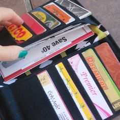 a person's hand is holding onto a wallet full of cards and credit cards