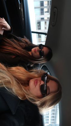 two women sitting in the back seat of a car