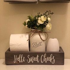 a bathroom shelf with toilet paper rolls and flowers