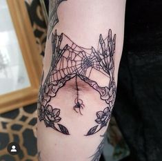 a woman's arm with a spider web tattoo on it