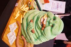 a cake made to look like a creature with hotdogs and fries on it