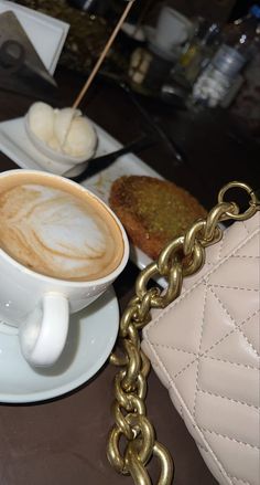 a cup of cappuccino on a saucer with a chain around it