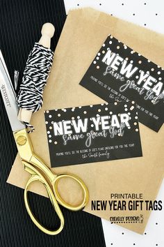 two new year's gift tags on top of a pair of scissors