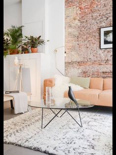 a living room filled with furniture and a brick wall in the back drop off area