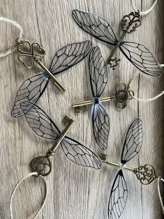 several dragonflys are attached to strings on a wooden surface