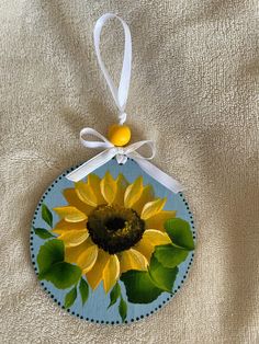 Yellow Sunflower hand painted 4" wood circle Christmas ornament.  This yellow sunflower ornament is bright and cheerful and will make you smile! This 4" wood circle ornament has a big bright yellow sunflower with leaves on a blue background. It is ready to hang on your tree with white ribbon already attached! The back of the ornament is blank so you can even write your own message on the back. Merry Christmas! Sunflower Christmas, Circle Ornament, Wood Christmas Tree, Shell Ornaments, Wood Circles, Sunflower Decor, Wood Christmas, Yellow Sunflower, White Ribbon