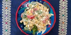 a blue and red plate topped with pasta salad