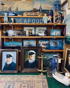 there are many paintings and pictures on the shelves in this room, including one with an old sailor's hat