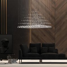 a living room with a black couch and a chandelier hanging from the ceiling