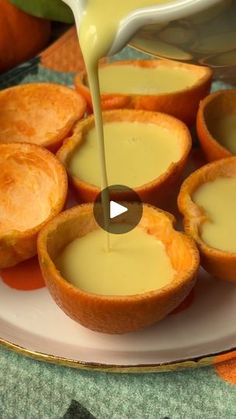 an orange is being drizzled with sauce on top of small pies