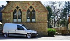 a white van parked in front of a brick building