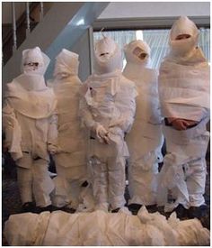 a group of people dressed in white paper