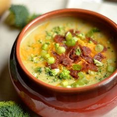 a bowl of soup with bacon and broccoli