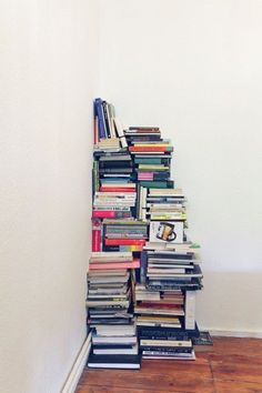 a book shelf filled with lots of books on top of white walls and flooring