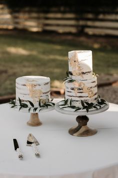 two white cakes sitting on top of a table