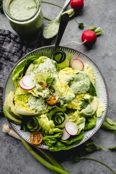 a salad in a bowl with dressing on the side