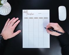 a person writing on a sheet of paper next to a computer mouse and coffee cup