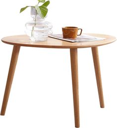 a wooden table with a glass vase on it and a coffee cup next to it