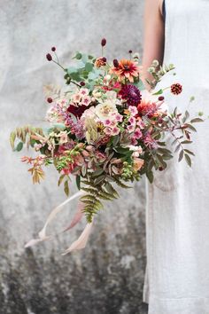 a woman holding a bouquet of flowers in her hand