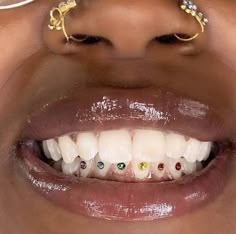 a close up of a person's mouth with fake teeth and piercings on it