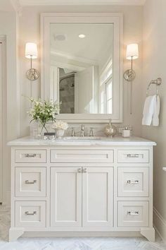 a white bathroom with two sinks and a large mirror