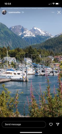 the boats are docked in the harbor with mountains in the background