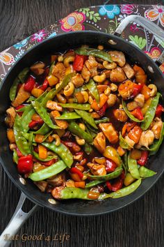 stir fry with chicken, peppers and cashews in a skillet