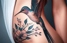 a woman's stomach with a hummingbird and flowers on it