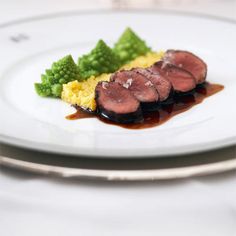 a white plate topped with meat and vegetables