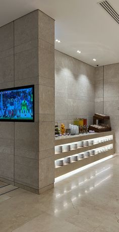 a large television mounted to the side of a wall next to a counter filled with food