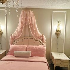 a bed with pink sheets and pillows in a room