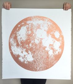 an orange and white poster with the moon in it's center, on a white background