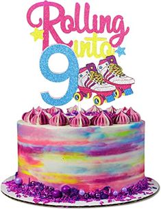 a colorful cake with the number nine on top and roller skates in the middle