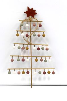 a wooden christmas tree with ornaments hanging from it's sides and a star on top