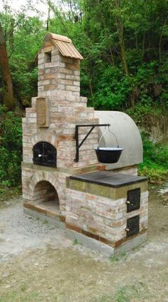 an outdoor brick pizza oven in the woods