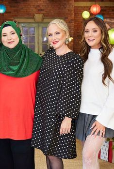 three women standing next to each other in front of christmas decorations