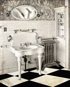 an old fashioned bathroom with black and white checkered flooring, pedestal sink and mirror